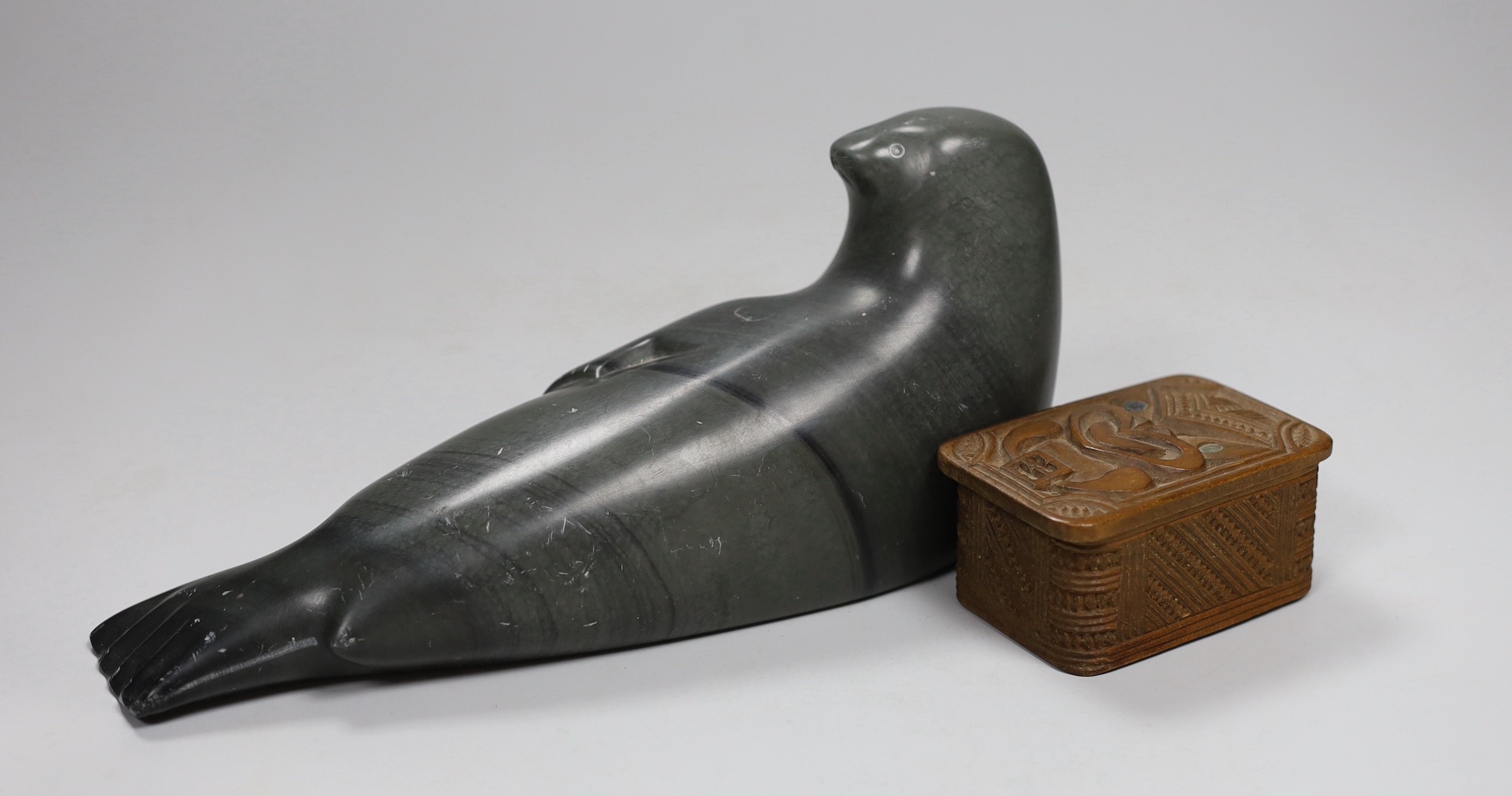 An Inuit stone figure of a seal and a Maori box and cover, carving 22cm long